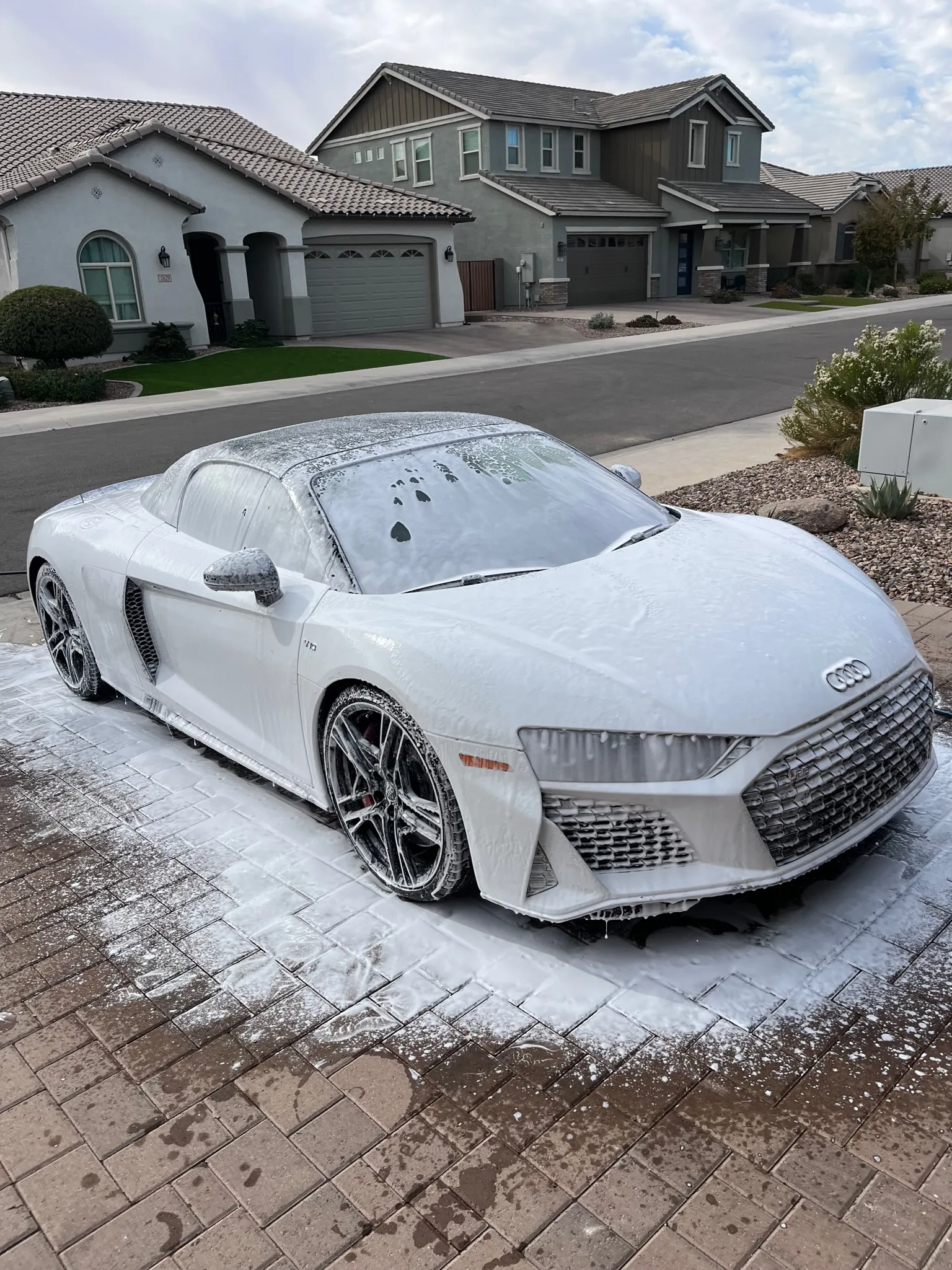 White Audi R8 covered in snow foam during a driveway hand wash