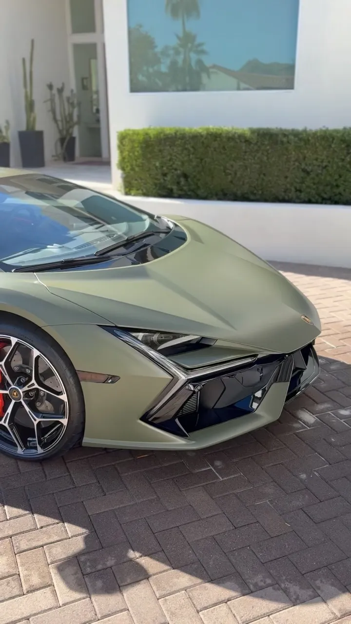 Front end of a matte green Lamborghini, paint evenly finished