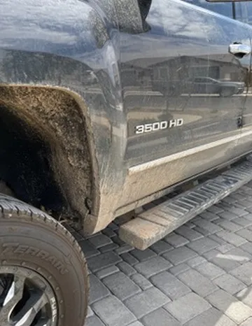 Truck tire and wheel coated in brake dust and road grime before cleaning