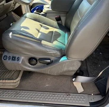 Car interior before detailing, with visible dirt and debris on the seats and carpet
