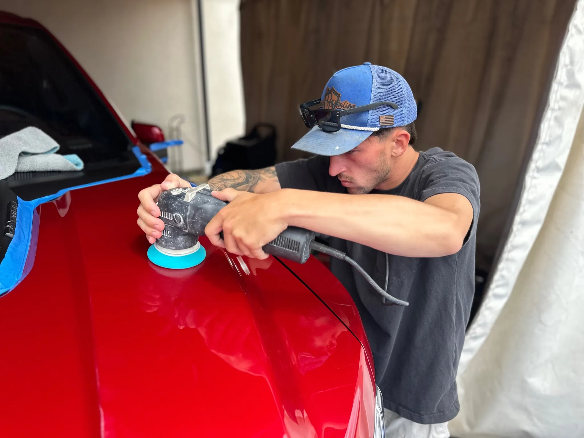 Mobile detailing setup at work on a vehicle in a residential driveway